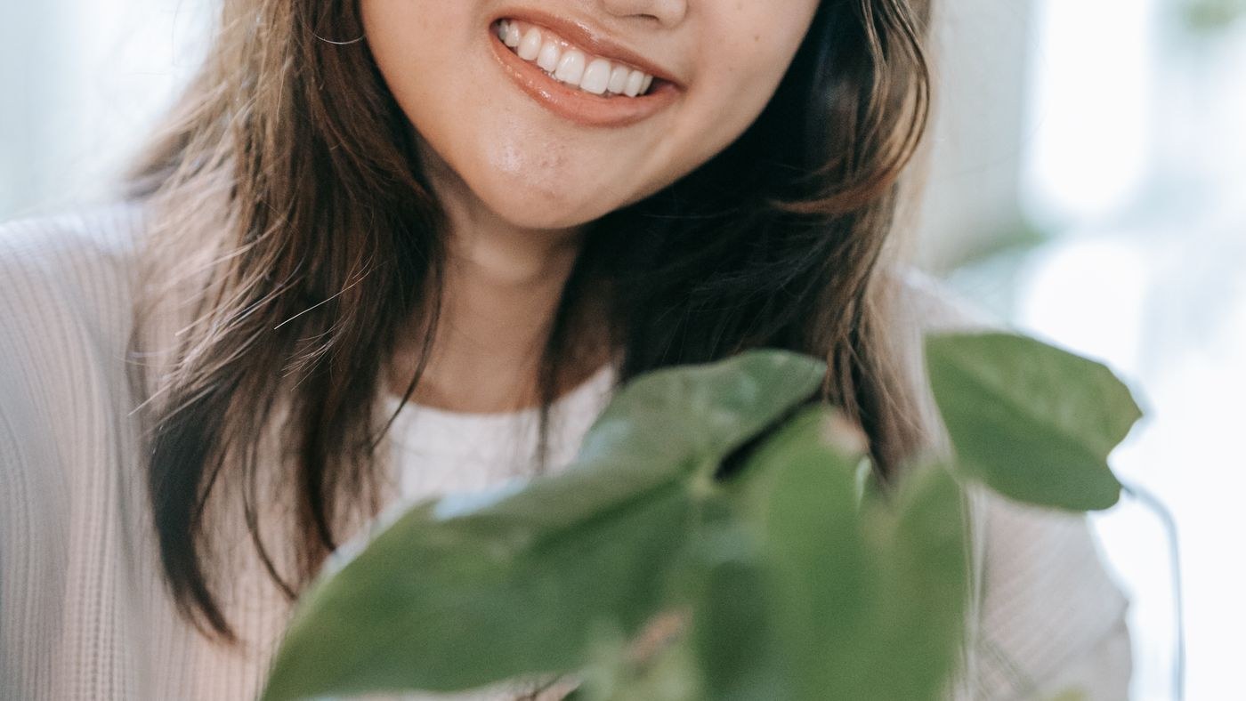 smiling gardener caring for an indoor plant